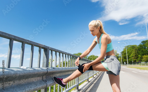 Obraz na plátně young woman with injured knee or leg outdoors