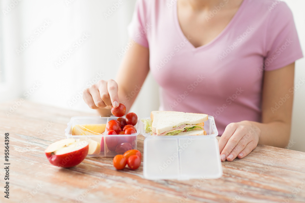 close up of woman with food in plastic container close up of woman with food in plastic container
