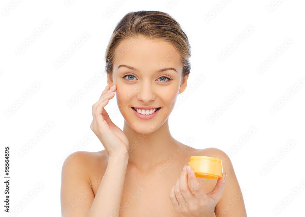 happy young woman appying cream to her face happy young woman appying cream to her face