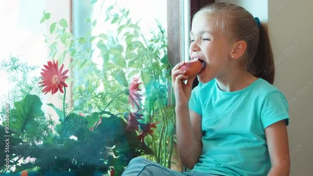 Portrait girl eating peach and sitting on the windowsill and looking out the window and looking at camera. Zooming Portrait girl eating peach and sitting on the windowsill and looking out the window and looking at camera. Zooming