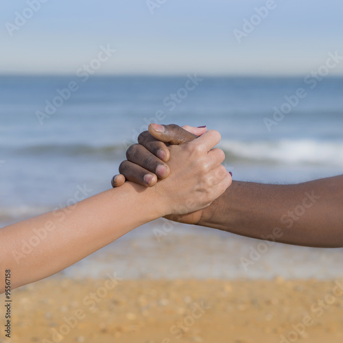 Man and woman holding each other’s hand (symbol of love and diversity)