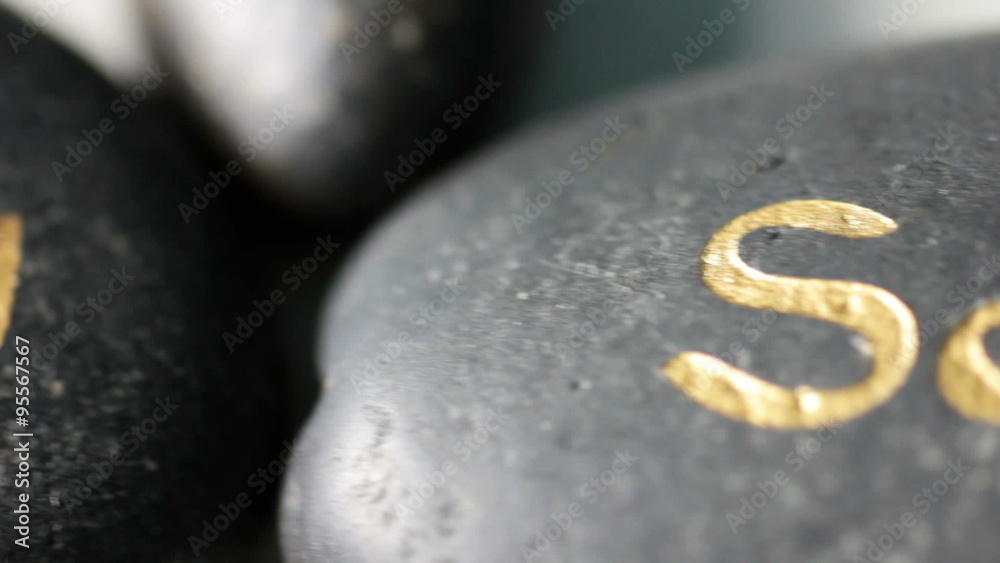 Panning across a selection of Spa hot rocks displaying the words relax body soul on top of the stones