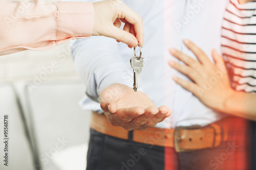 Real estate agent giving keys to young couple