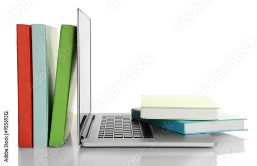 Stack of books with laptop isolated on white