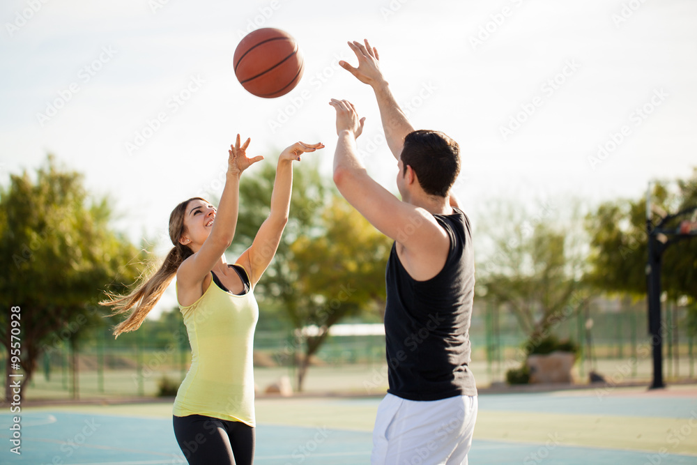 Fototapeta premium Active couple playing basketball on a first date