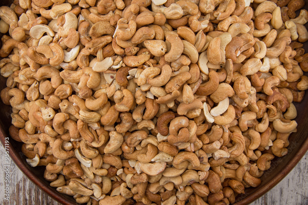 Raw cashews close-up in wooden bowl Raw cashews close-up in wooden bowl