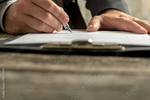Closeup of businessman signing contract, document or legal paper