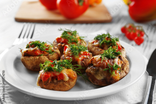 Served table with stuffed mushrooms on white wooden background, close-up