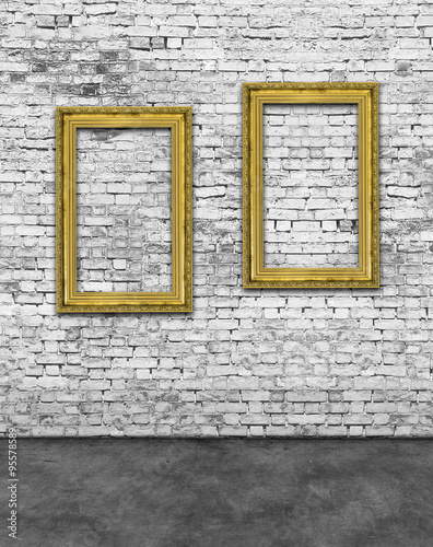 Two vertical golden frames on brick wall