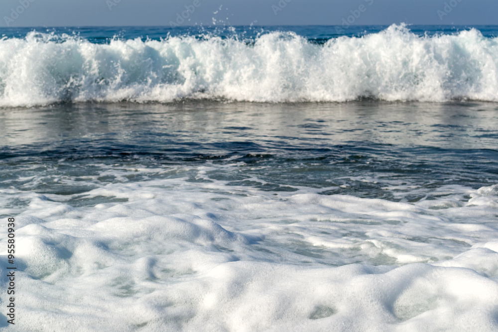 Waves breaking on a stony beach, forming sprays Waves breaking on a stony beach, forming sprays