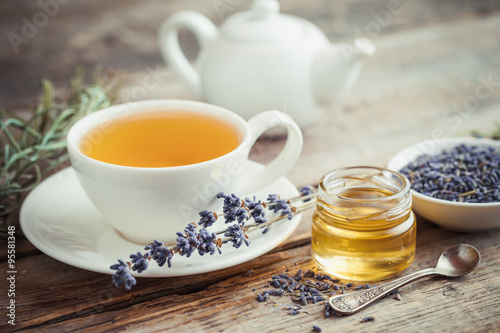 Healthy tea cup, jar of honey, dry lavender flowers and teapot o