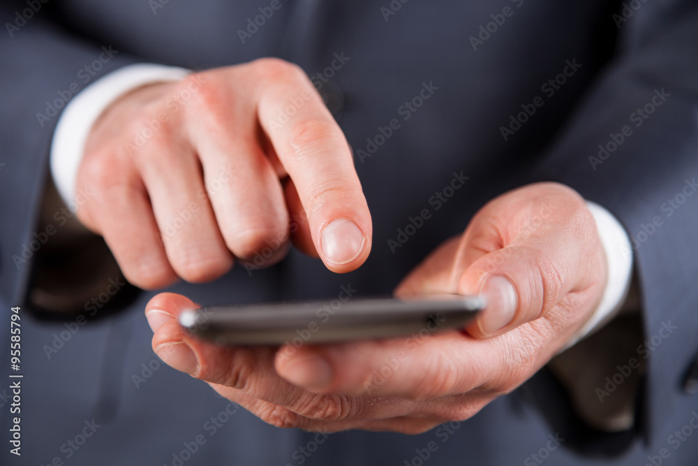 Unrecognizable businessman holding a cellphone Unrecognizable businessman holding a cellphone