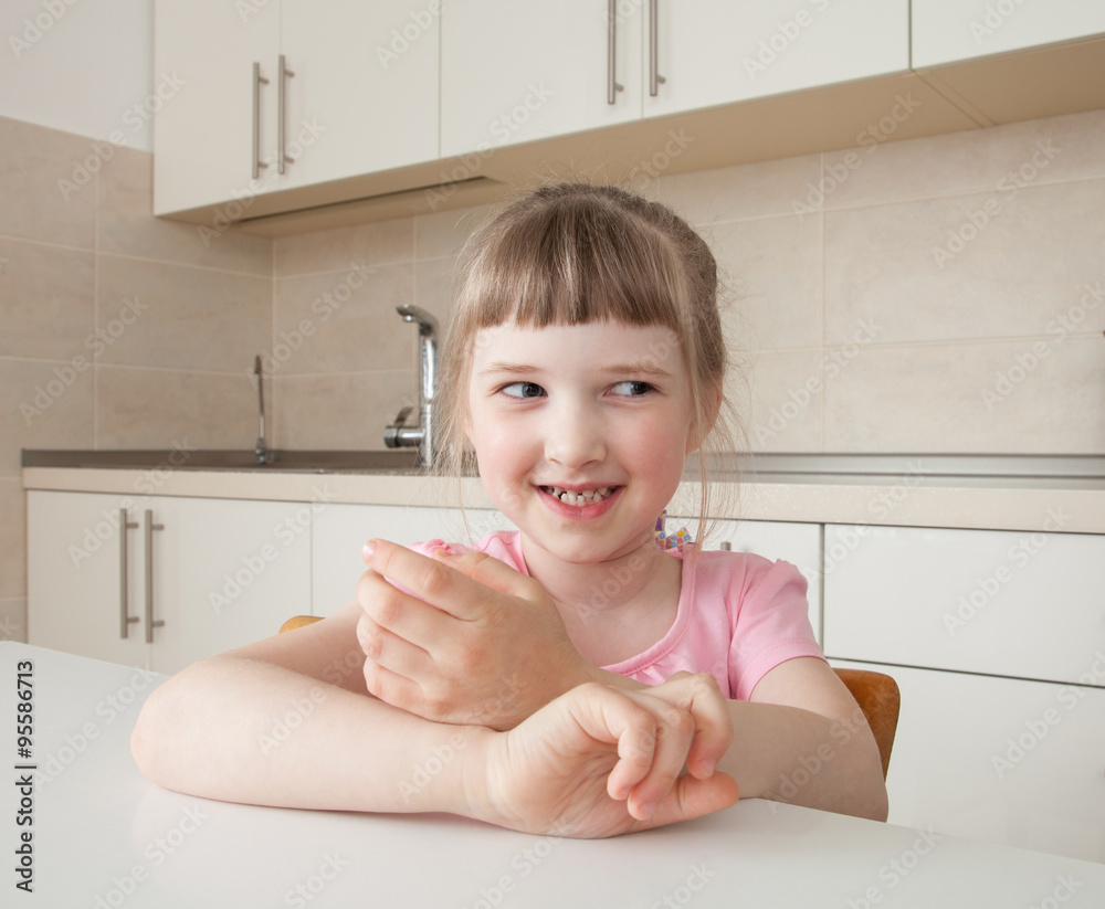Happy little girl sitting at table