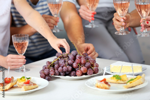 Friends hands with glasses of wine and snacks  close up