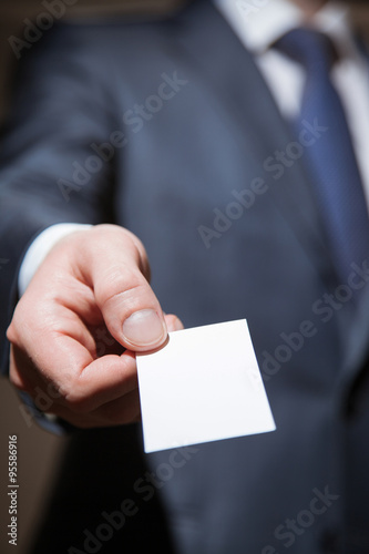 Man's hand reaching out a business card