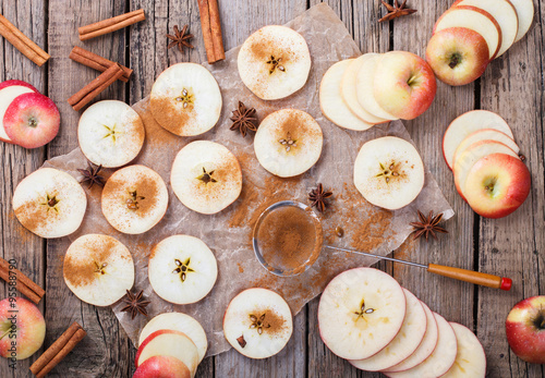 Apples sliced with cinnamon on old wooden background.selective focus. photo