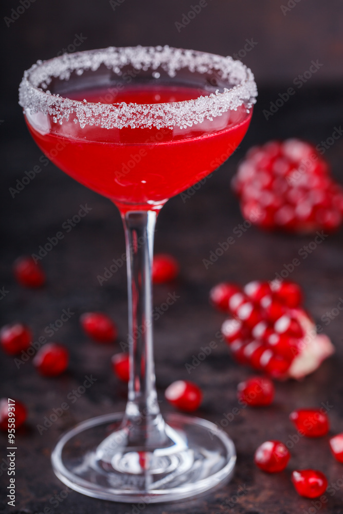 Red alcoholic cocktail with raspberry and pomegranate, in a glass glass on a black background. selective focus.