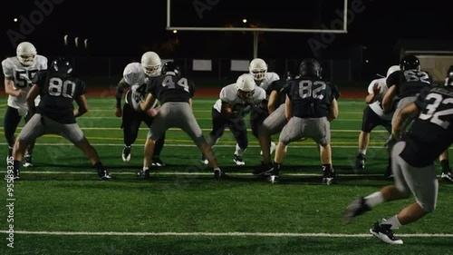 A football player gets tackled right before throwing the ball
