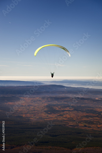 Yellow paragliding on plain with fall colors