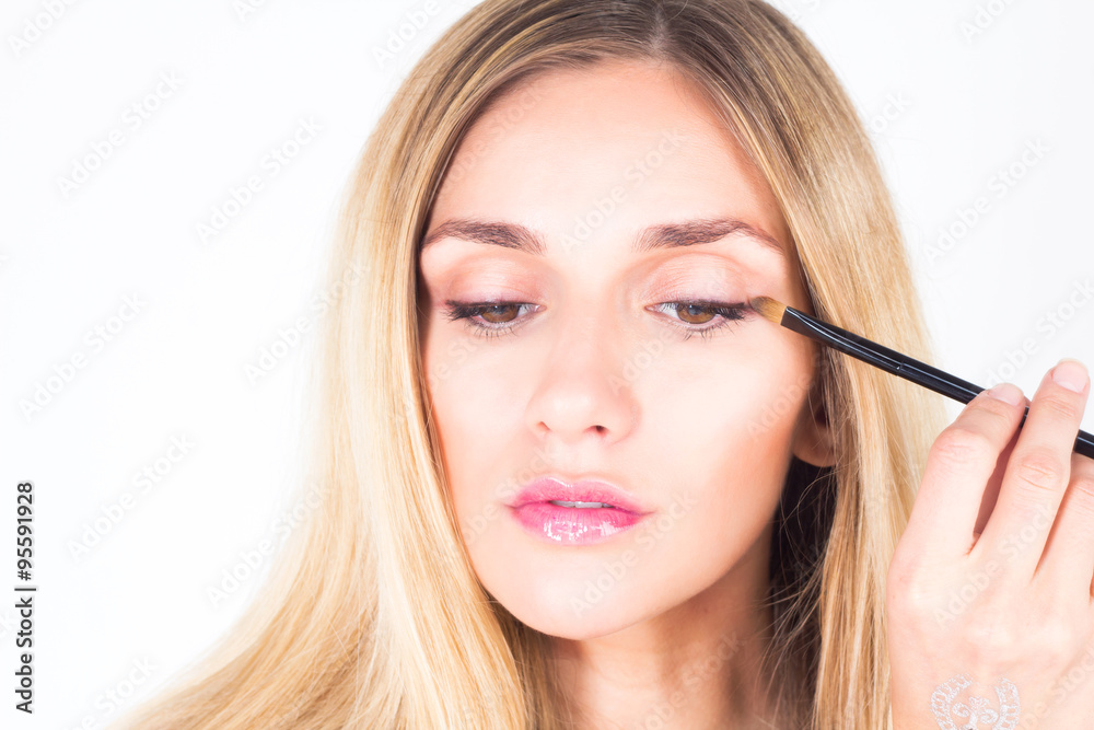 Beautiful woman looking down and apply shade on eyelid Beautiful woman looking down and apply shade on eyelid