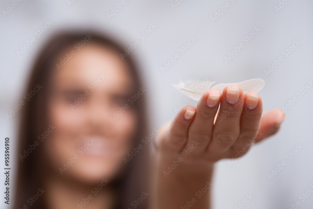 woman balancing a feather on her hand