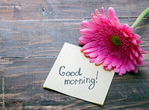 Gerbera flower and paper with text "good morning"