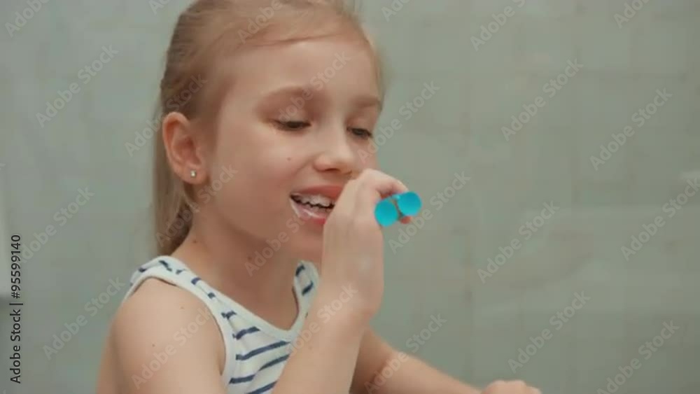 Closeup portrait girl cleaning teeth after meals and looking at camera Closeup portrait girl cleaning teeth after meals and looking at camera