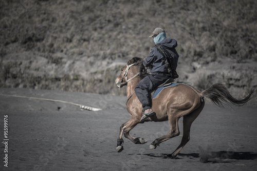 Fototapeta Naklejka Na Ścianę i Meble -  Horse rider on desert near Bromo Mountain Java ,Indonesia.