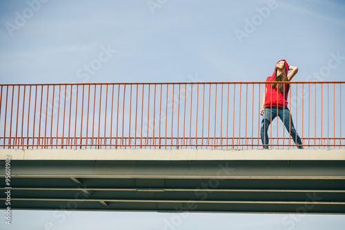 Girl on bridge in city.