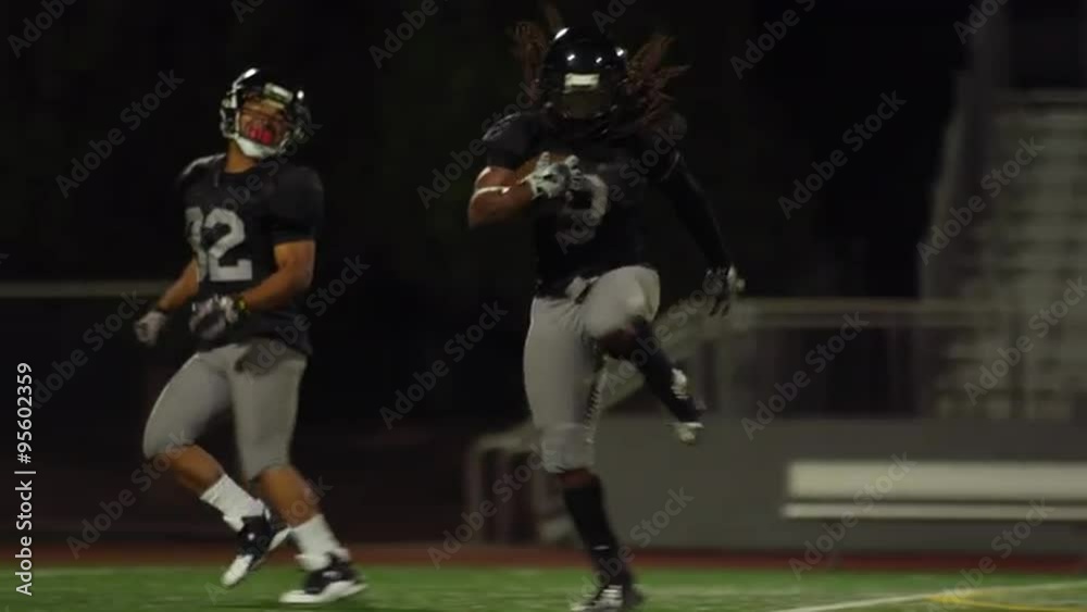 A football player runs past the defense and makes a touchdown, in slow motion A football player runs past the defense and makes a touchdown, in slow motion