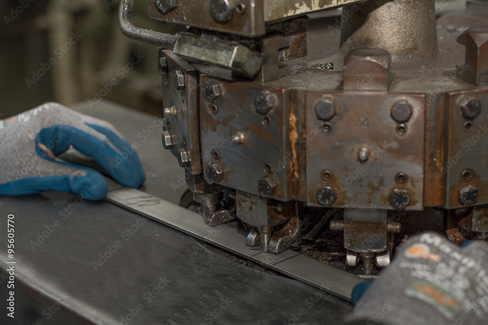 Löcher werden mit Maschine in Metallteile gestanzt Löcher werden mit Maschine in Metallteile gestanzt