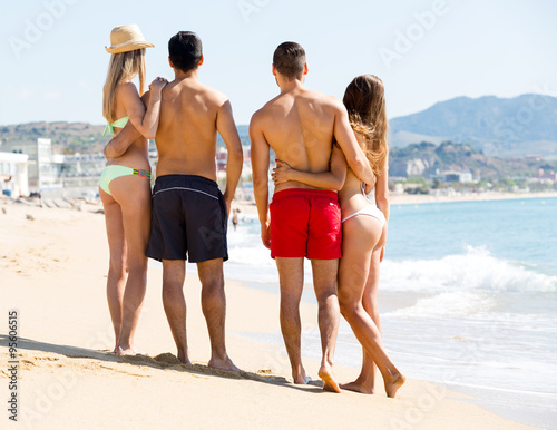 hugging couples on beach