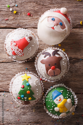 Christmas cupcakes closeup on a wooden table. vertical top view