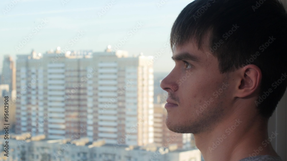Man in glass home takes a look at view outside Man in glass home takes a look at view outside