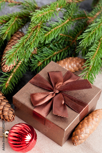 brown gift box, Christmas ball and Green fir branches on black b