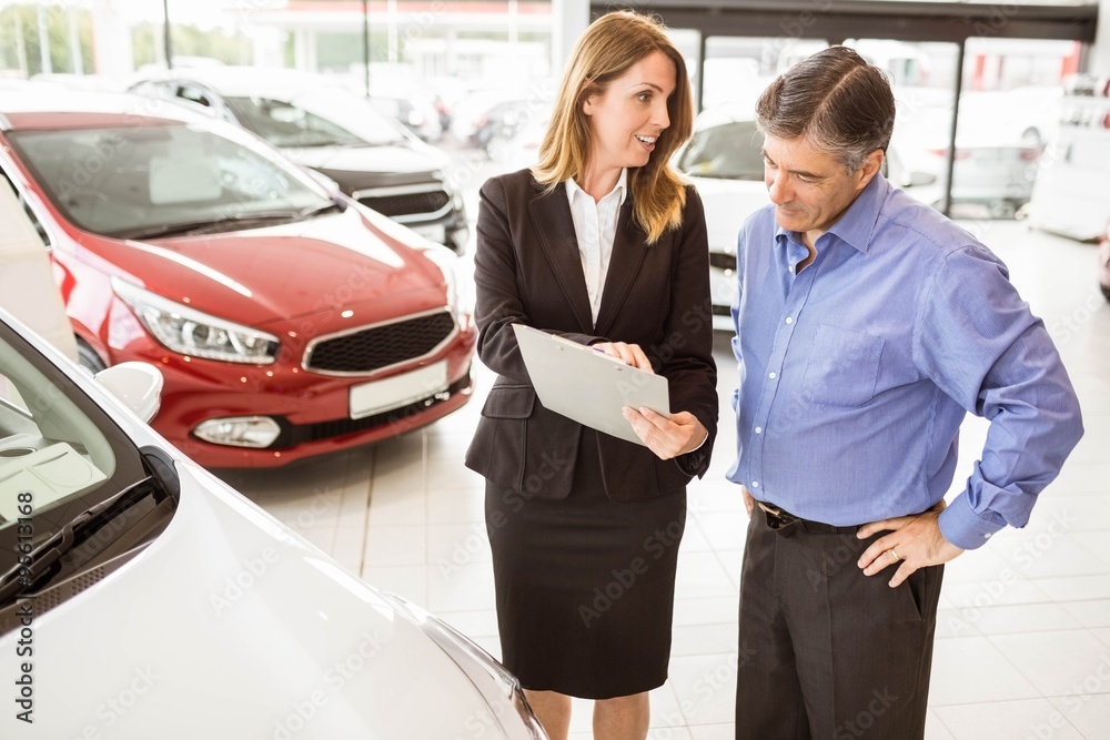 Smiling businessman undersign a car contract Smiling businessman undersign a car contract