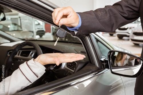 Salesman offering car key to a customers © WavebreakMediaMicro