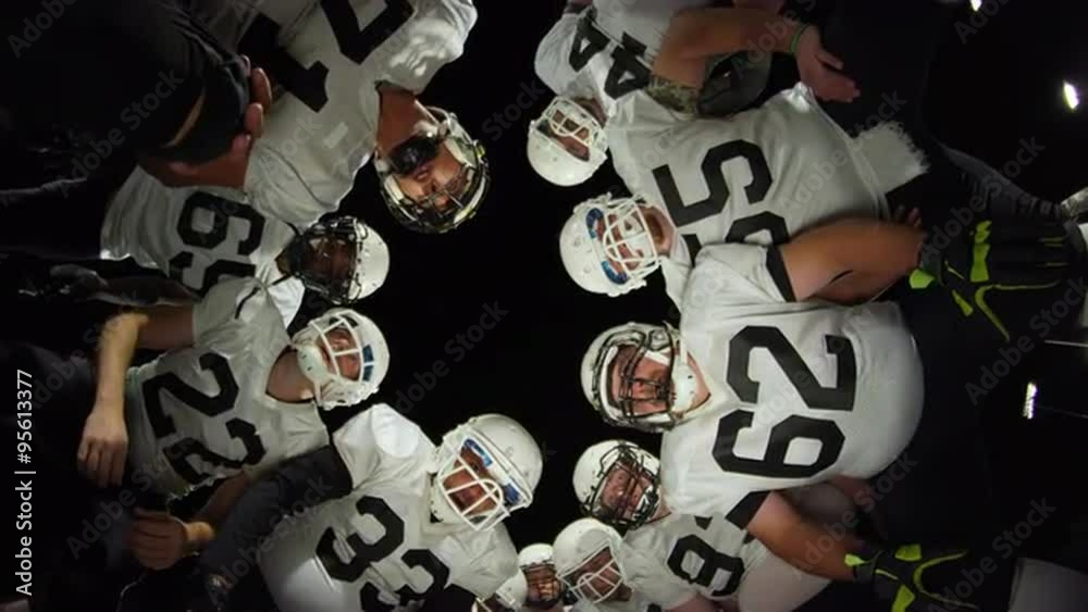 Low angle view looking up at football players inside a huddle