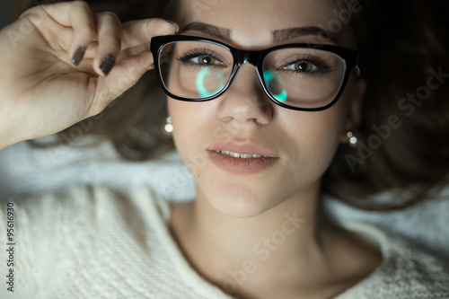 Sexy woman in glasses lies on bed