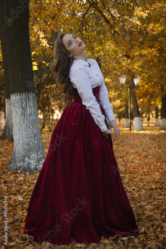 Woman dressed in a retro-style on the autumn alley