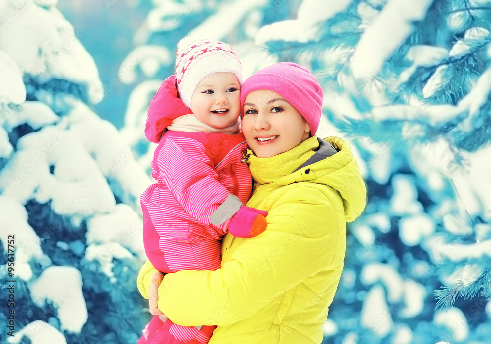 Fototapeta premium Happy smiling mother and child having fun together in snowy wint