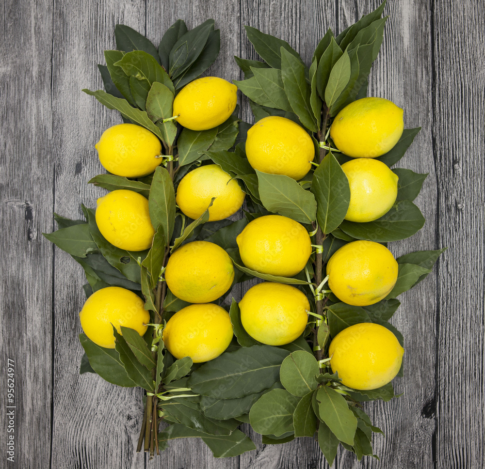 Branch of fresh juicy Sicilian lemons on a wooden background