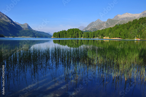 Spiegelnder Silsersee mit Blick auf die Halbinsel Chasté