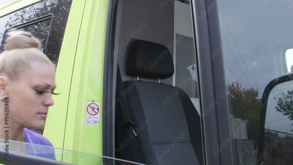 Female paramedic in ambulance talking with dispatcher on radio and driving to destination Female paramedic in ambulance talking with dispatcher on radio and driving to destination