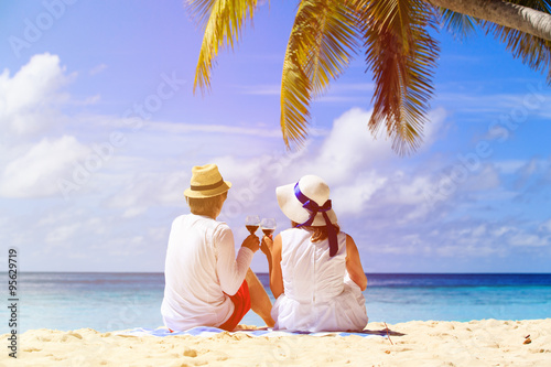 happy loving couple drinking wine at beach