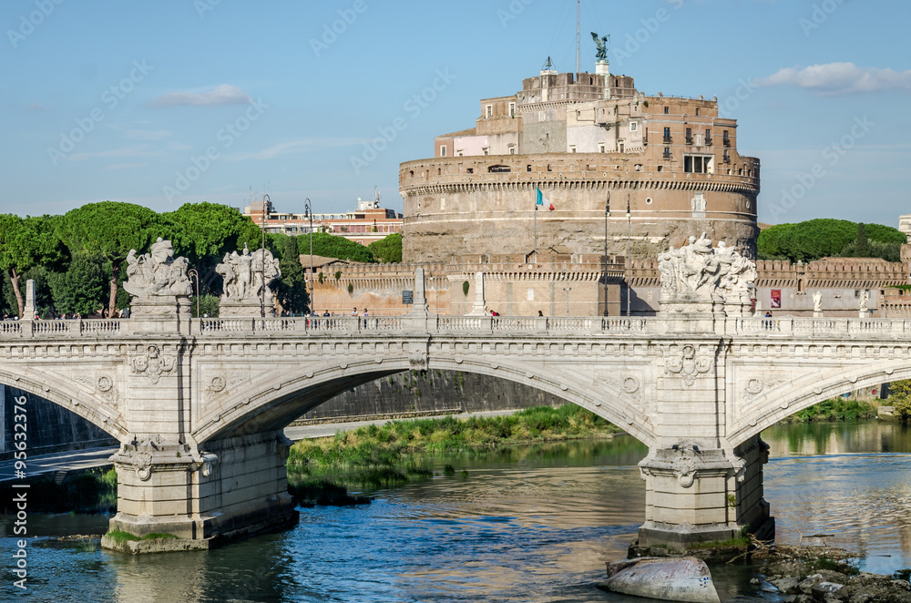 Historic sights of building architecture Castel Sant'Angelo in Rome, on the banks of the Tiber River near the arched bridge across the river on a bright sunny day