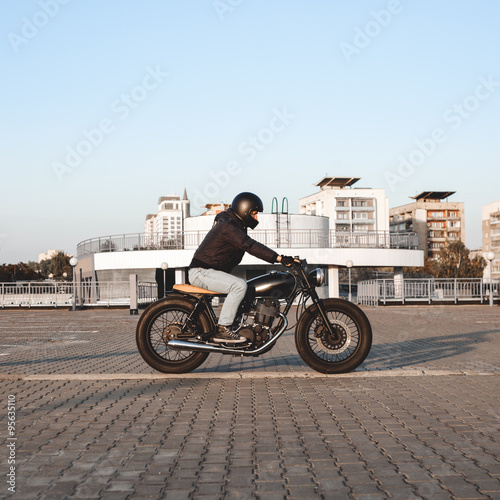 Motorcyclist riding on a motorcycle in parking lot in city