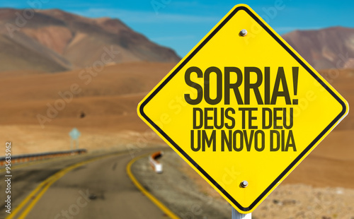 Smile! God Gives You Another Day (in Portuguese) sign on desert road
