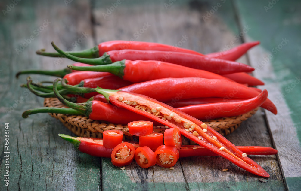 basket full of red chili peppers on wood basket full of red chili peppers on wood