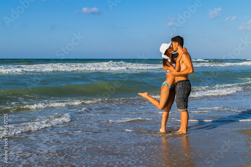 Fototapeta Naklejka Na Ścianę i Meble -  Attractive young couple in bikini and shorts at the beach.